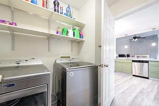 washroom with a ceiling fan, laundry area, light wood-style flooring, a sink, and washer and clothes dryer