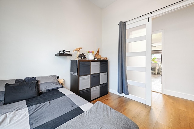 bedroom featuring wood finished floors and baseboards