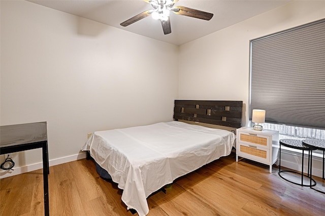 bedroom featuring ceiling fan, baseboards, and wood finished floors