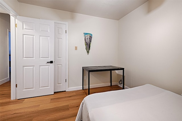 bedroom with baseboards and wood finished floors