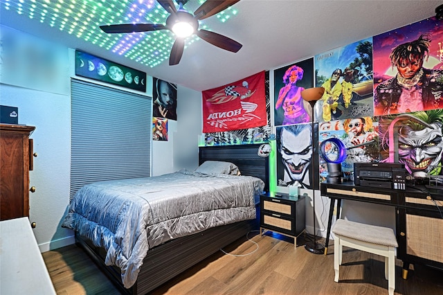 bedroom featuring baseboards, a ceiling fan, and wood finished floors