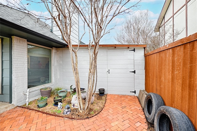 view of patio with an outbuilding and fence