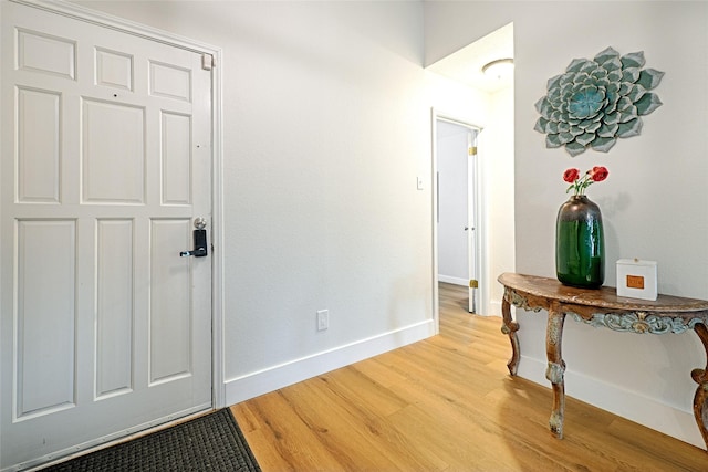 corridor featuring light wood-style flooring and baseboards