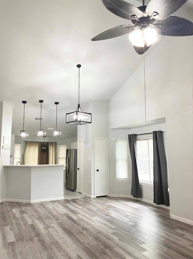 unfurnished living room featuring visible vents, high vaulted ceiling, light wood-type flooring, and a ceiling fan