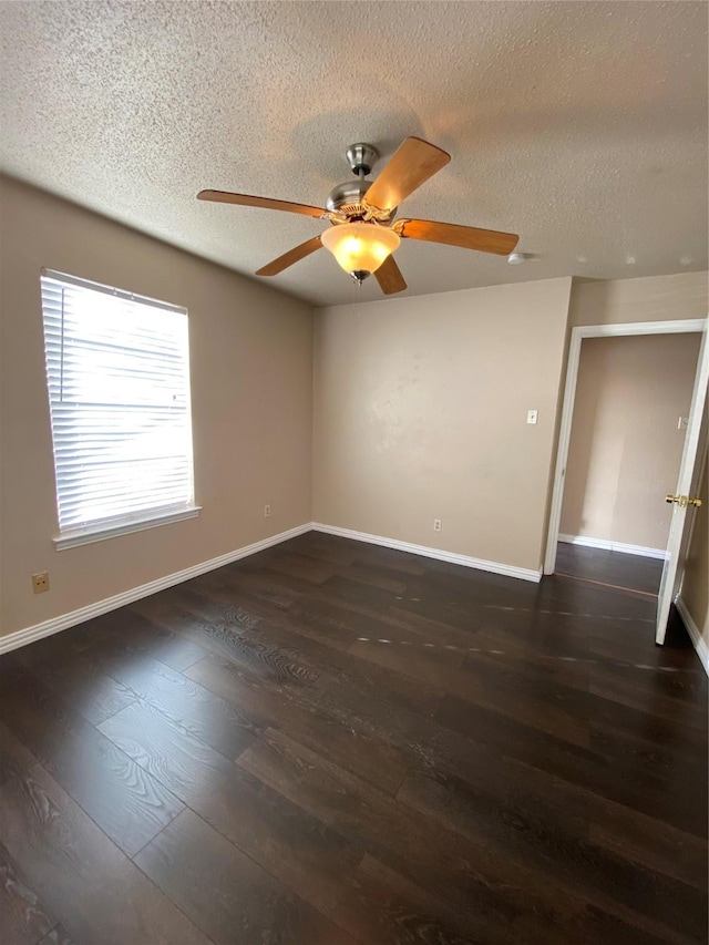 unfurnished room with ceiling fan, a textured ceiling, dark wood-type flooring, and baseboards