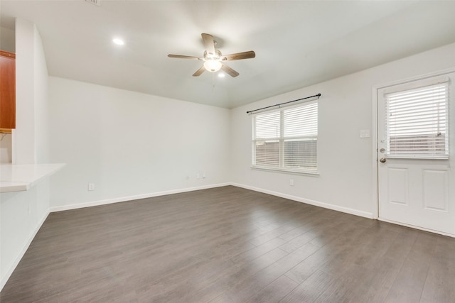 unfurnished living room with recessed lighting, a ceiling fan, dark wood-type flooring, and baseboards