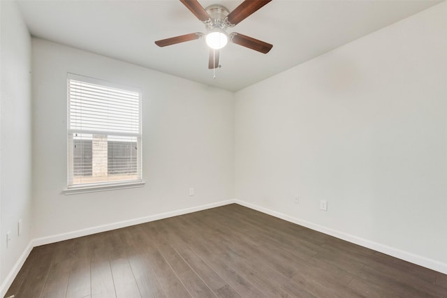 spare room featuring dark wood finished floors, ceiling fan, and baseboards