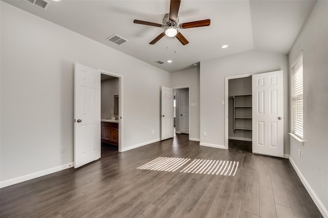 unfurnished bedroom with visible vents, baseboards, a spacious closet, and dark wood-style flooring