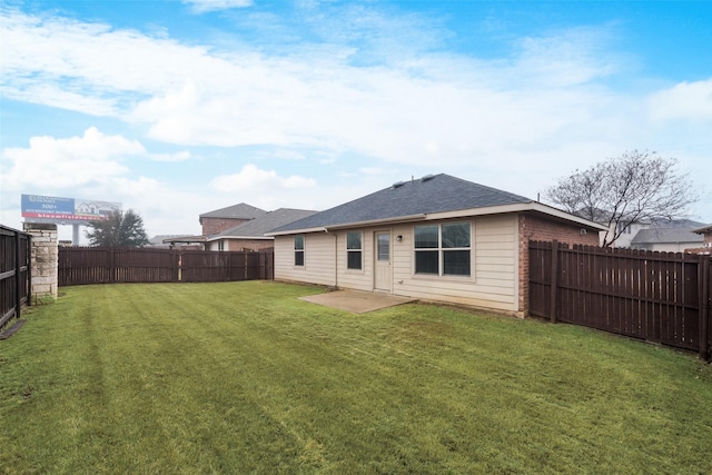 rear view of property with brick siding, a lawn, a fenced backyard, and roof with shingles