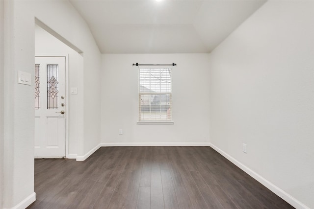 unfurnished room with dark wood-type flooring, baseboards, and vaulted ceiling