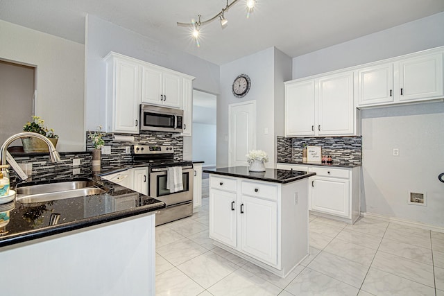 kitchen featuring marble finish floor, a sink, dark stone countertops, white cabinetry, and stainless steel appliances