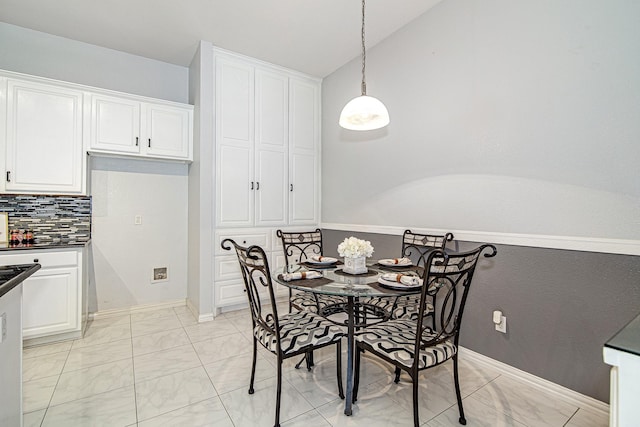 dining area with marble finish floor, baseboards, and vaulted ceiling