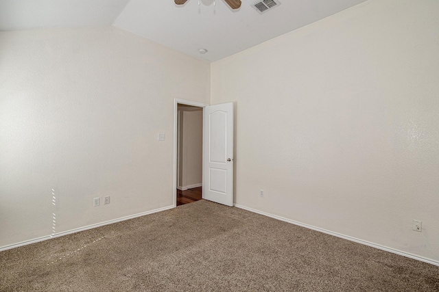unfurnished room with baseboards, visible vents, carpet floors, ceiling fan, and vaulted ceiling