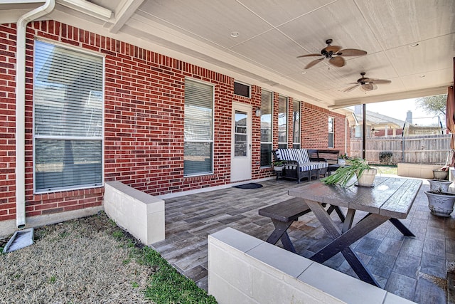 exterior space with outdoor lounge area, fence, and ceiling fan