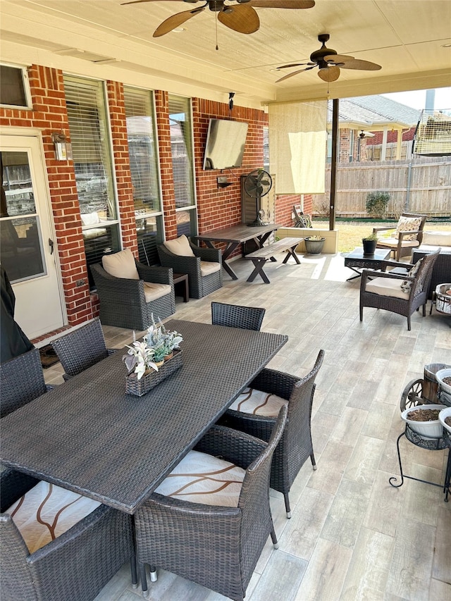 view of patio featuring a ceiling fan, an outdoor living space, and fence