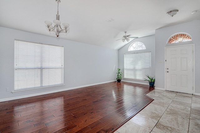 entrance foyer featuring light wood-type flooring, lofted ceiling, baseboards, and ceiling fan with notable chandelier