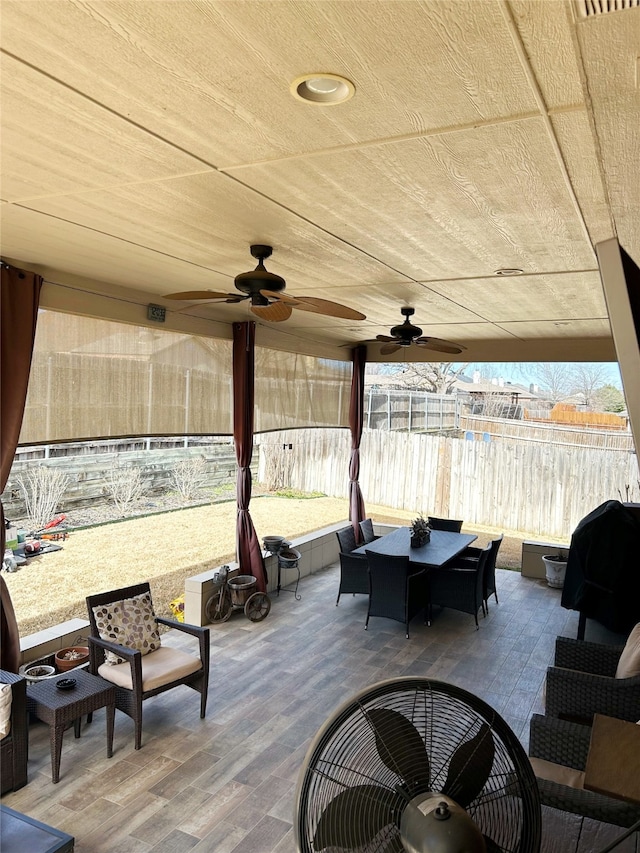 view of patio with outdoor dining area, a fenced backyard, and a ceiling fan