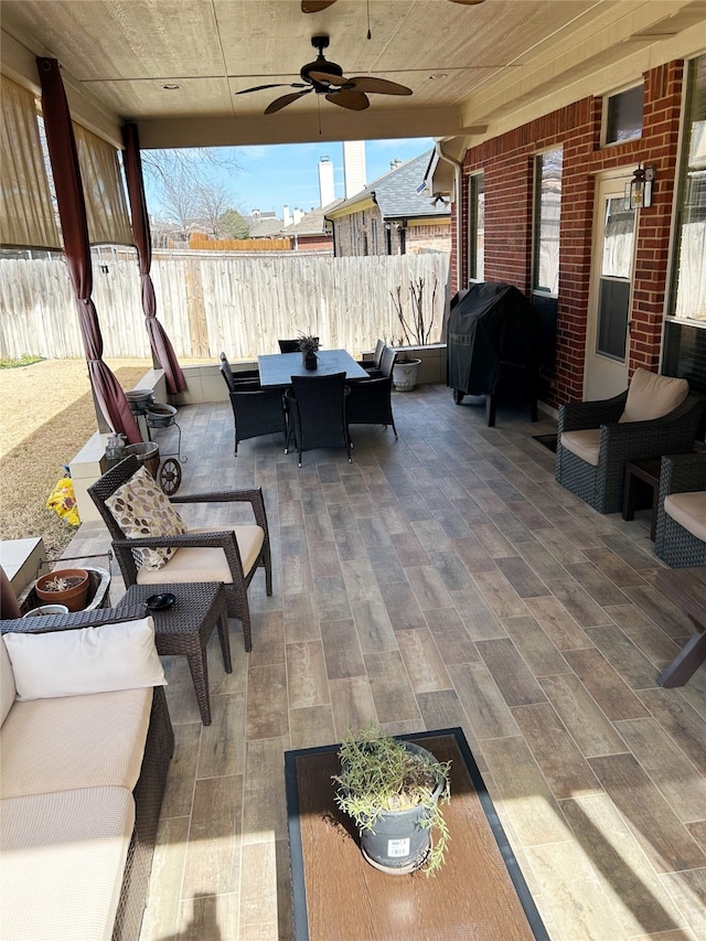 view of patio / terrace with a ceiling fan, outdoor dining area, fence, and a grill