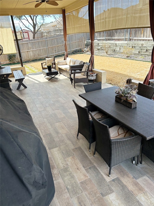 view of patio with an outdoor living space, outdoor dining area, a fenced backyard, and ceiling fan