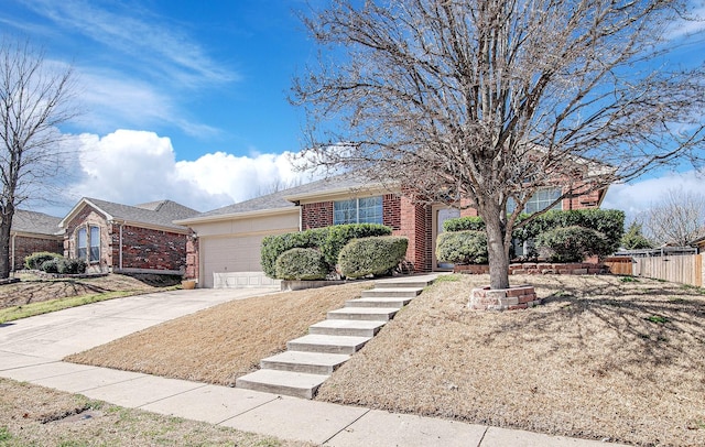 ranch-style house with an attached garage, fence, brick siding, and driveway