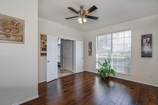 unfurnished room with a ceiling fan, baseboards, and hardwood / wood-style flooring
