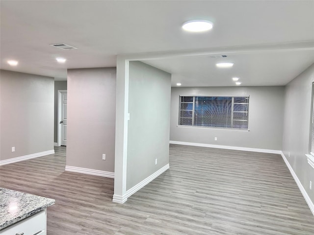 below grade area with recessed lighting, visible vents, light wood-style flooring, and baseboards