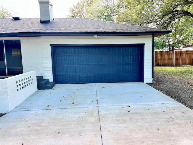 garage with driveway and fence