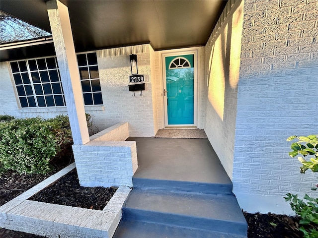 view of exterior entry featuring brick siding