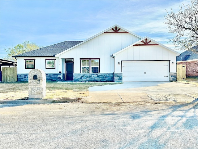 view of front facade with driveway, fence, a garage, and board and batten siding