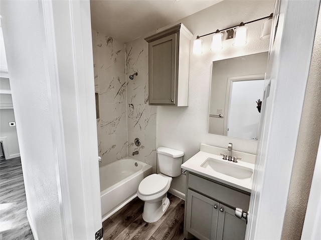 full bathroom featuring baseboards, toilet, bathing tub / shower combination, wood finished floors, and vanity