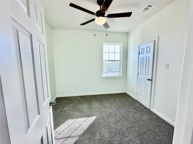 unfurnished bedroom with a ceiling fan, baseboards, visible vents, and dark carpet