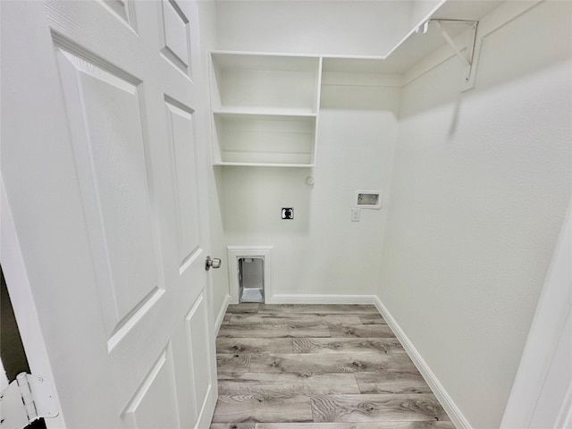 clothes washing area featuring electric dryer hookup, wood finished floors, baseboards, hookup for a washing machine, and laundry area