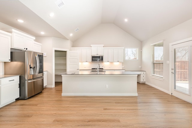 kitchen with a sink, white cabinets, light wood-type flooring, and stainless steel appliances