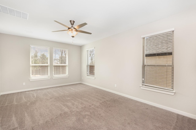 spare room with visible vents, baseboards, carpet, and a ceiling fan