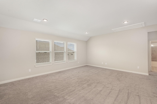 unfurnished room featuring recessed lighting, baseboards, carpet, lofted ceiling, and attic access