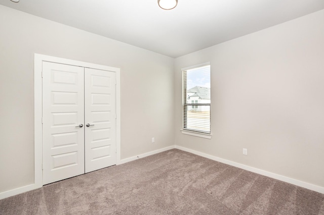 carpeted spare room featuring baseboards