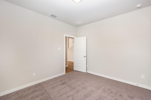 empty room with visible vents, carpet, and baseboards