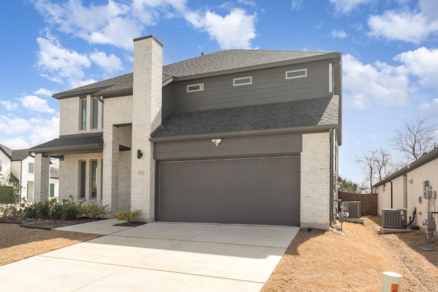 view of front of house with cooling unit, brick siding, roof with shingles, and a garage