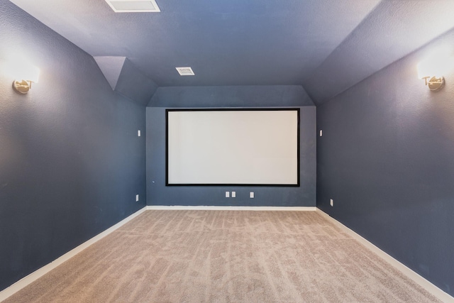 cinema room featuring carpet floors, baseboards, and vaulted ceiling