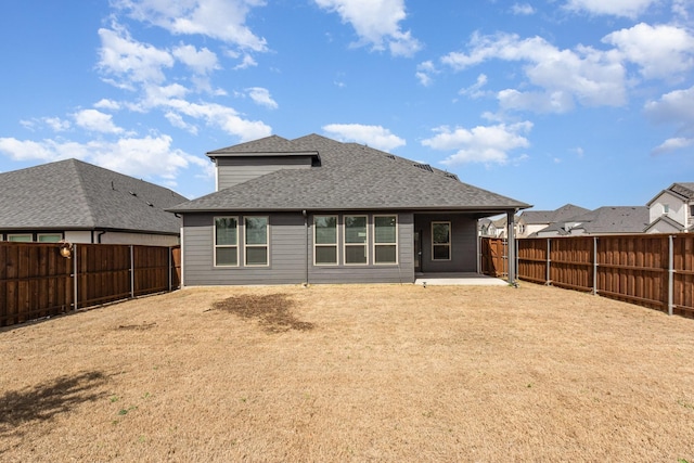 back of house featuring roof with shingles, a fenced backyard, and a patio area