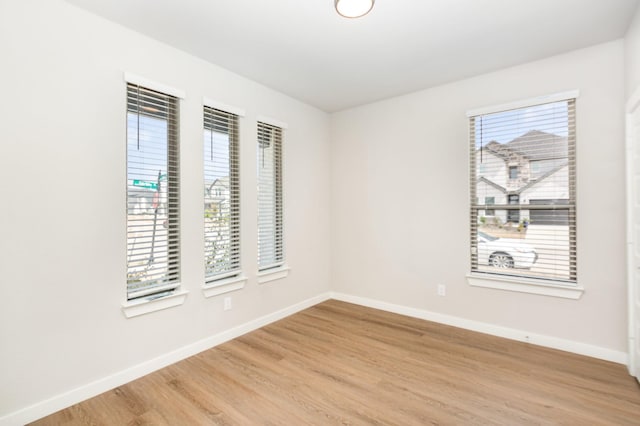 spare room with light wood-style flooring and baseboards