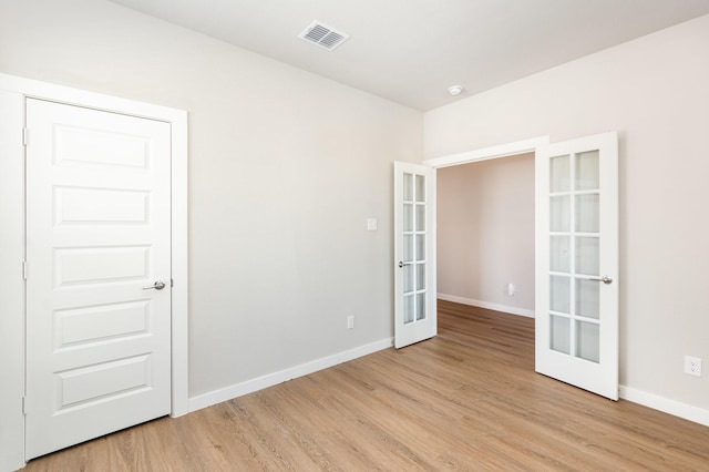 spare room with light wood-style flooring, french doors, visible vents, and baseboards