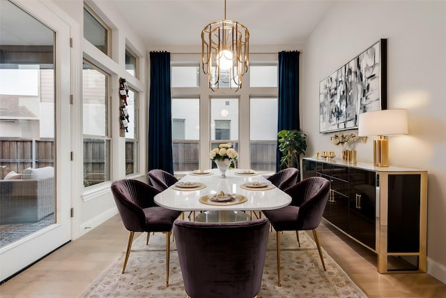 dining area with a chandelier, baseboards, a wealth of natural light, and wood finished floors