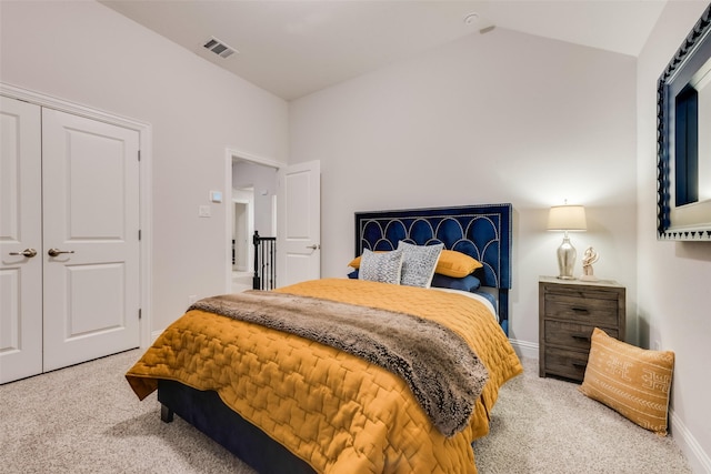 carpeted bedroom featuring baseboards, visible vents, lofted ceiling, and a closet