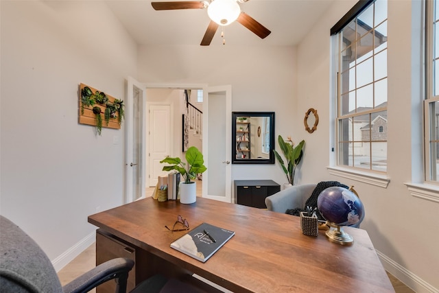 office area featuring baseboards and a ceiling fan