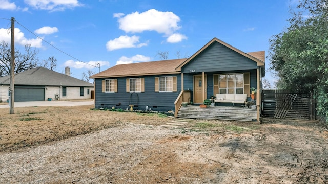 view of front of property featuring crawl space, a garage, a porch, and an outdoor structure