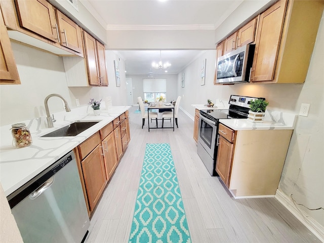 kitchen featuring light stone countertops, stainless steel appliances, ornamental molding, a sink, and light wood-type flooring