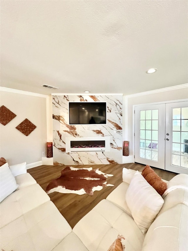 living room featuring visible vents, french doors, crown molding, and wood finished floors