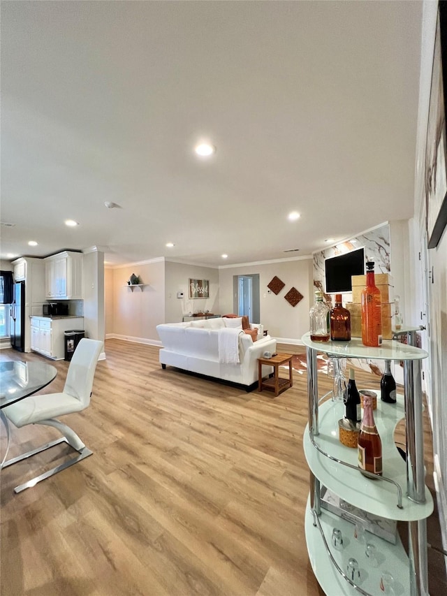 living room with recessed lighting, baseboards, light wood-style floors, and ornamental molding