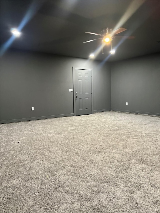 spare room with carpet flooring, baseboards, and ceiling fan